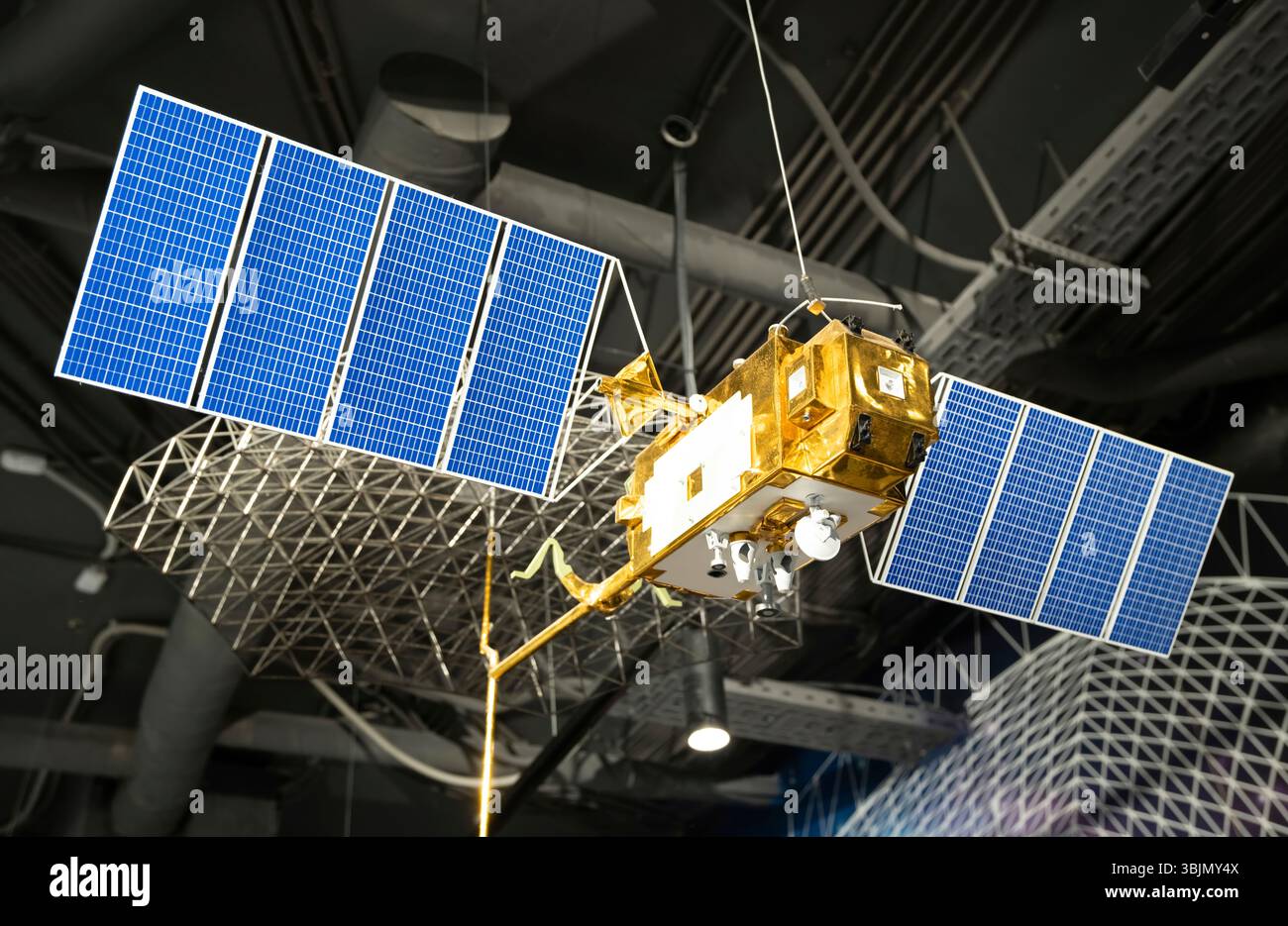 Un modello di satellite spaziale con pannelli solari e parti mostrato in un planetario Foto Stock