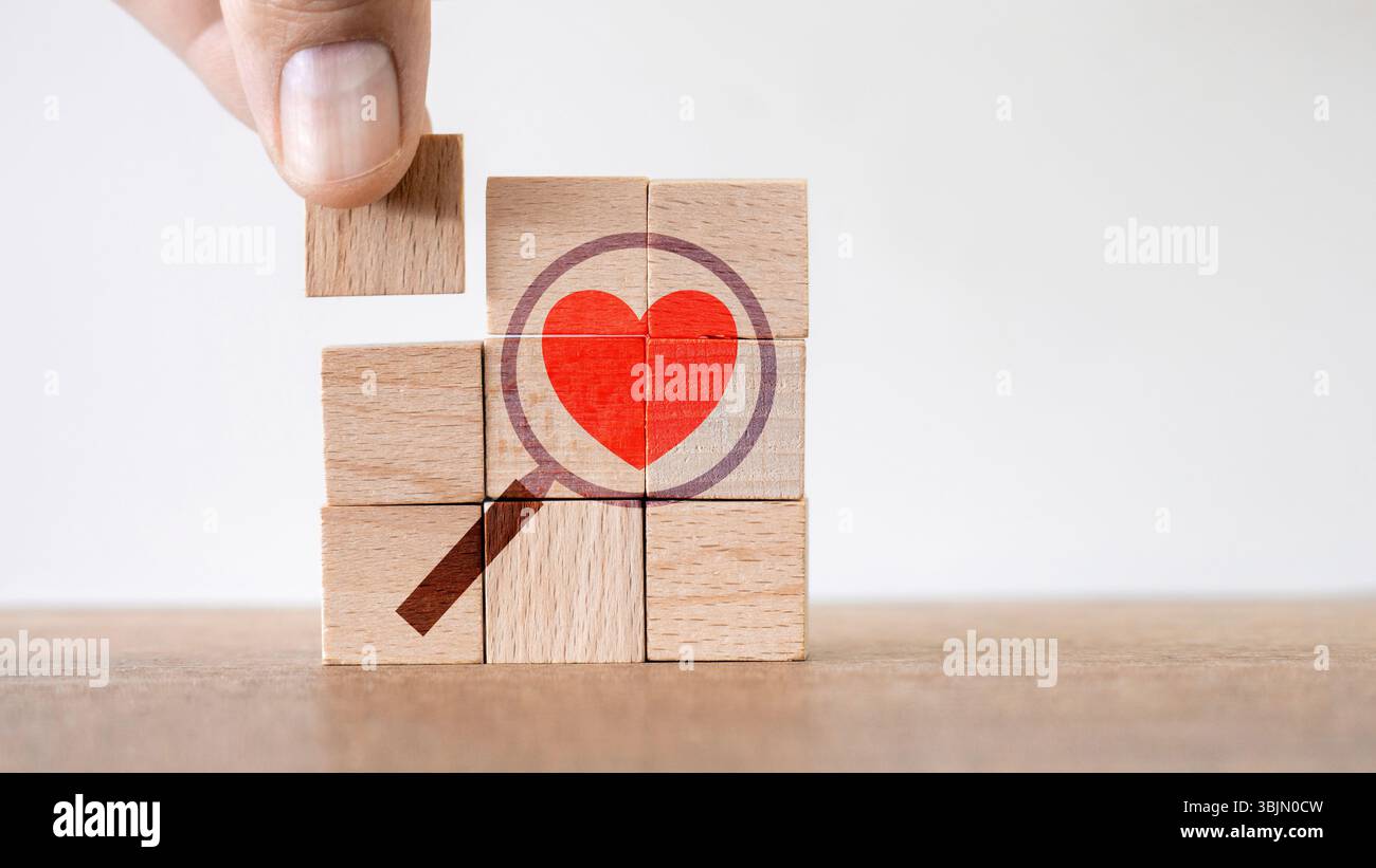 Colorate illustrazioni a forma di cuore su blocchi di legno simboleggiano la ricerca dell'amore e dell'amicizia Foto Stock