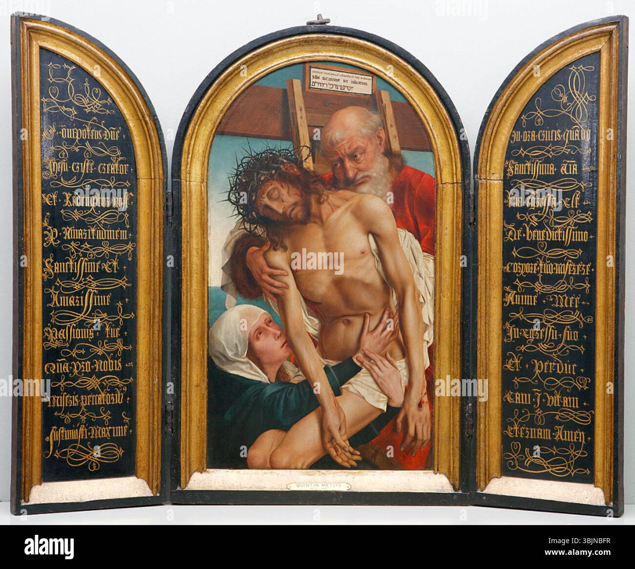 "Descendimiento" di Quentin Metsys, dipinto nel 1500, mostra la scena biblica della deposizione, con figure in lutto. Il pannello centrale raffigura l'evento, affiancato da testi biblici in lettere dorate. Foto Stock