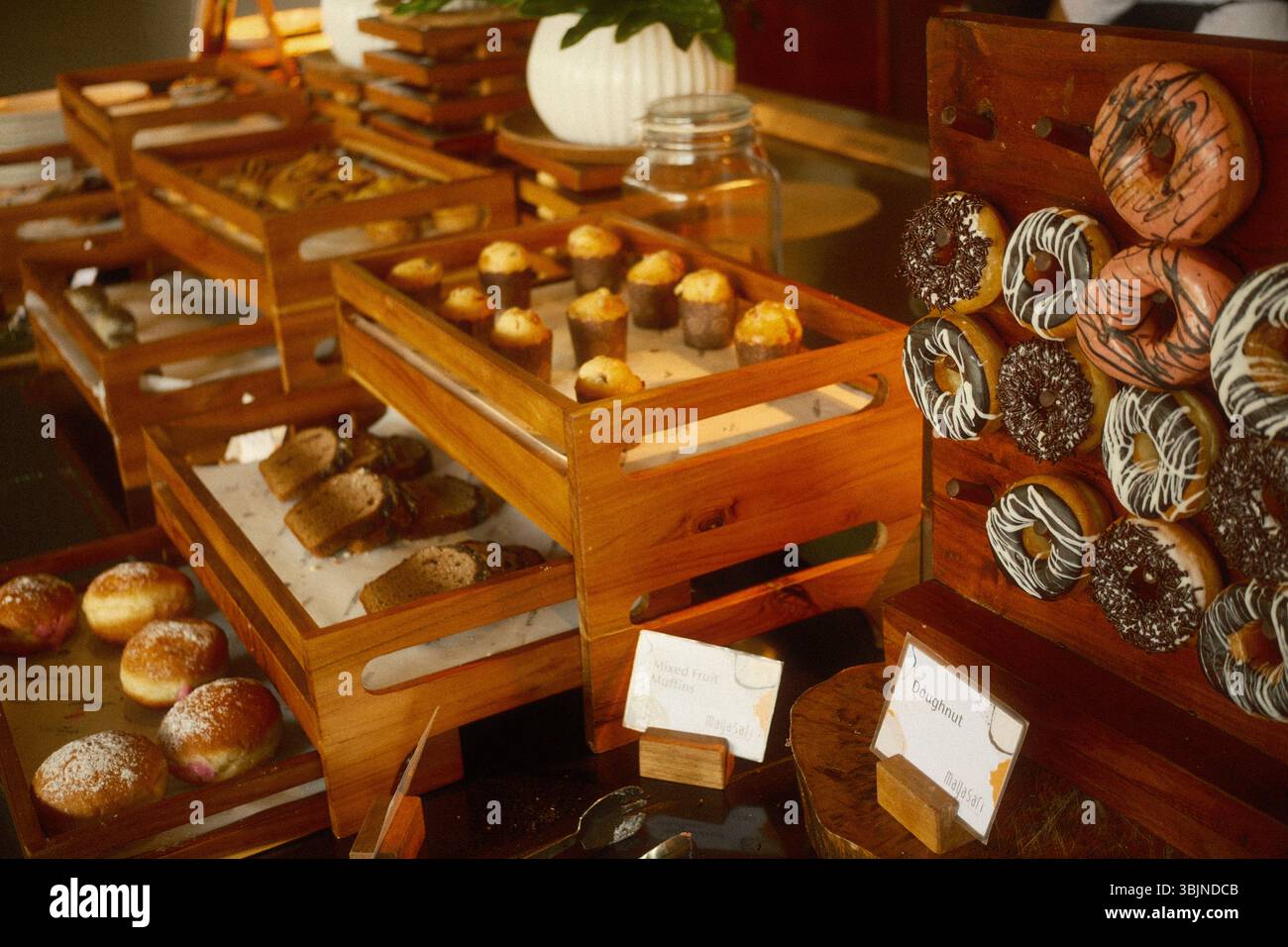 Ubud, Bali, Indonesia – 12 maggio 2025: Dolci assortiti, muffin, pane e ciambelle esposti presso i banchi della colazione a buffet del resort Foto Stock