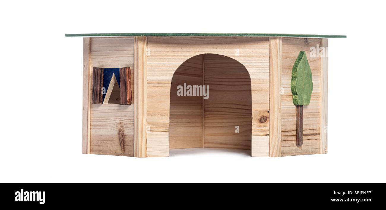 Adorabile casa in legno con tetto verde, piccola finestra e albero decorativo, perfetta per piccoli animali domestici Foto Stock