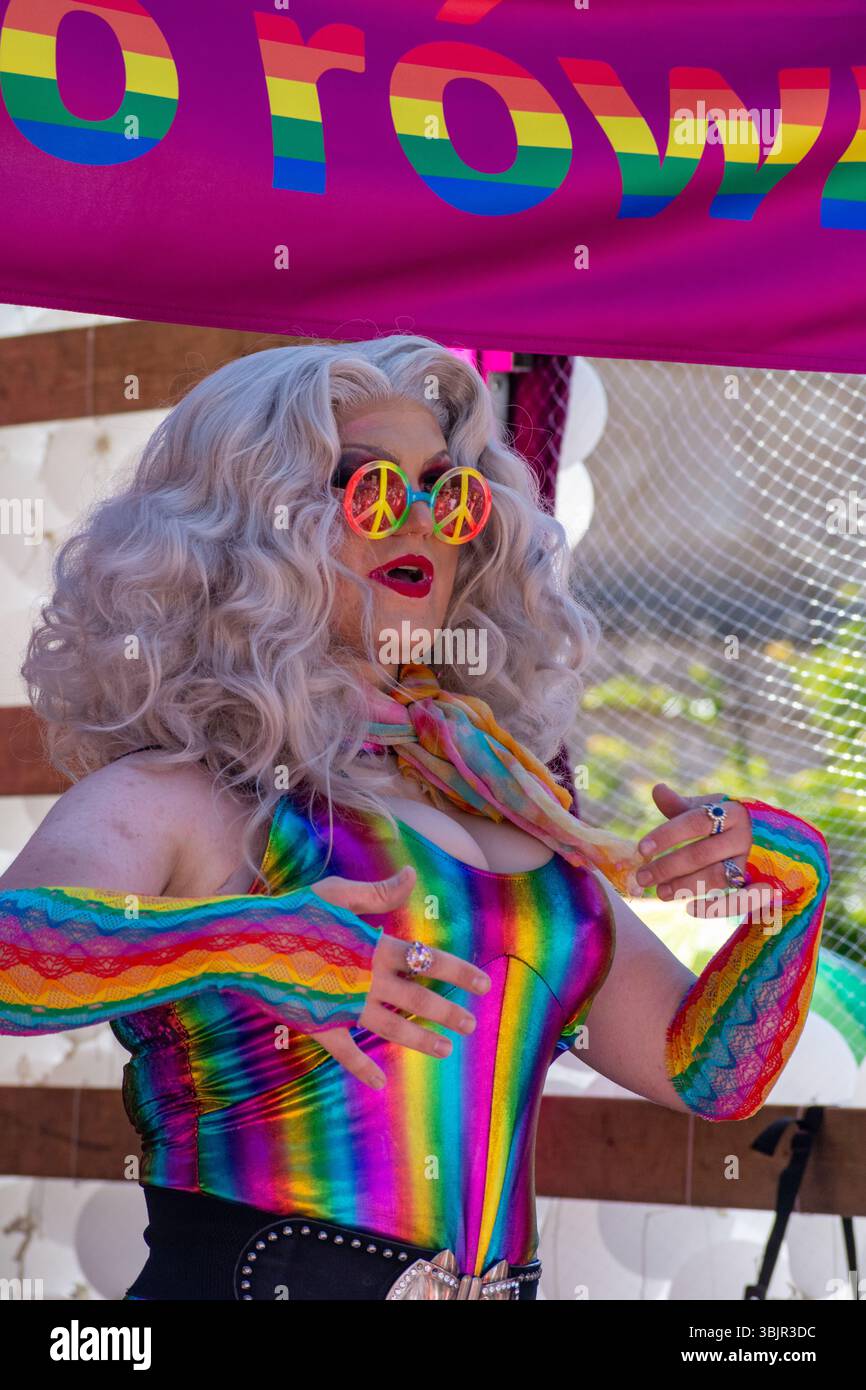 Un artista vestito di arcobaleno che indossa occhiali da sole simbolo della pace e una parrucca d'argento alla Parata del Pride di Varsavia a Varsavia, Masovian, Polonia, giugno 2025 Foto Stock