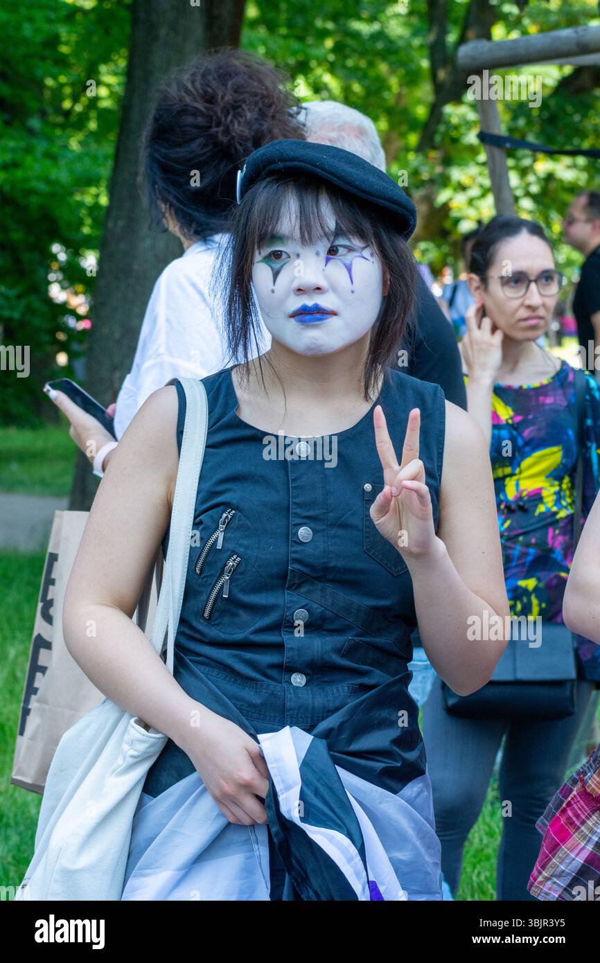 Un partecipante che indossa una vernice per il viso bianca e blu e un gilet nero irradiano un segno di pace durante la Equality Parade a Varsavia, Masovian, Polonia 2025 Foto Stock