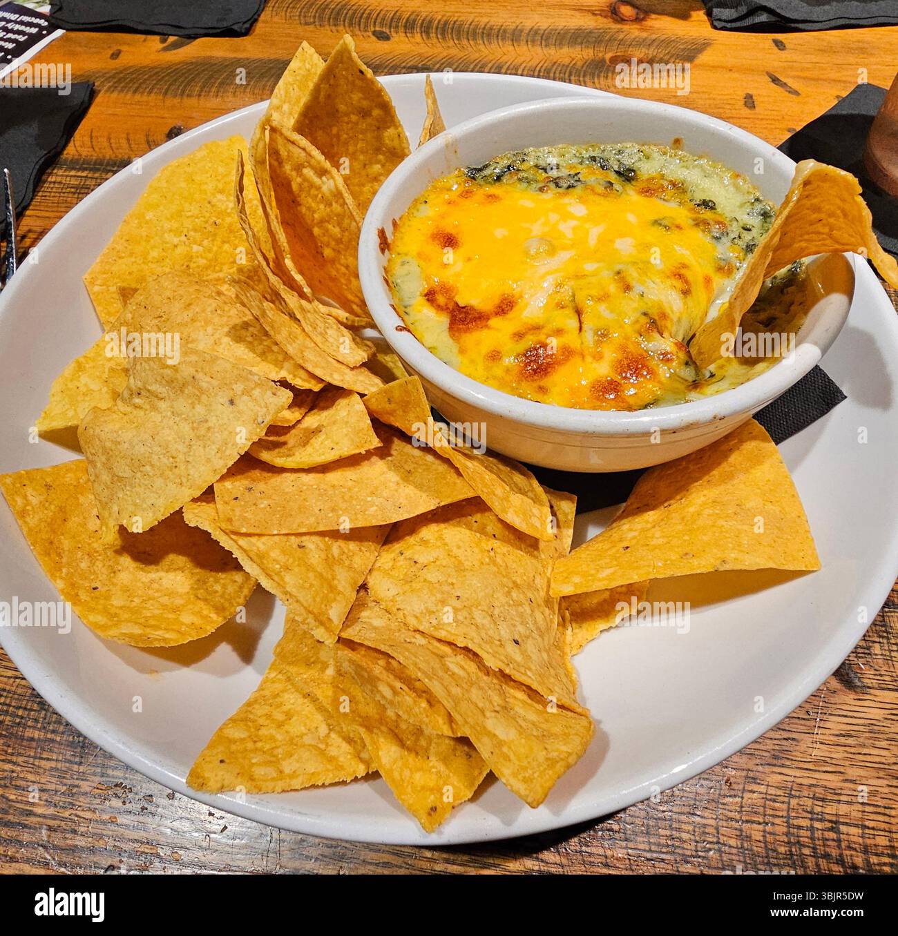 Salsa di carciofi agli spinaci con tortilla chips - Immagine stock catturata con smartphone