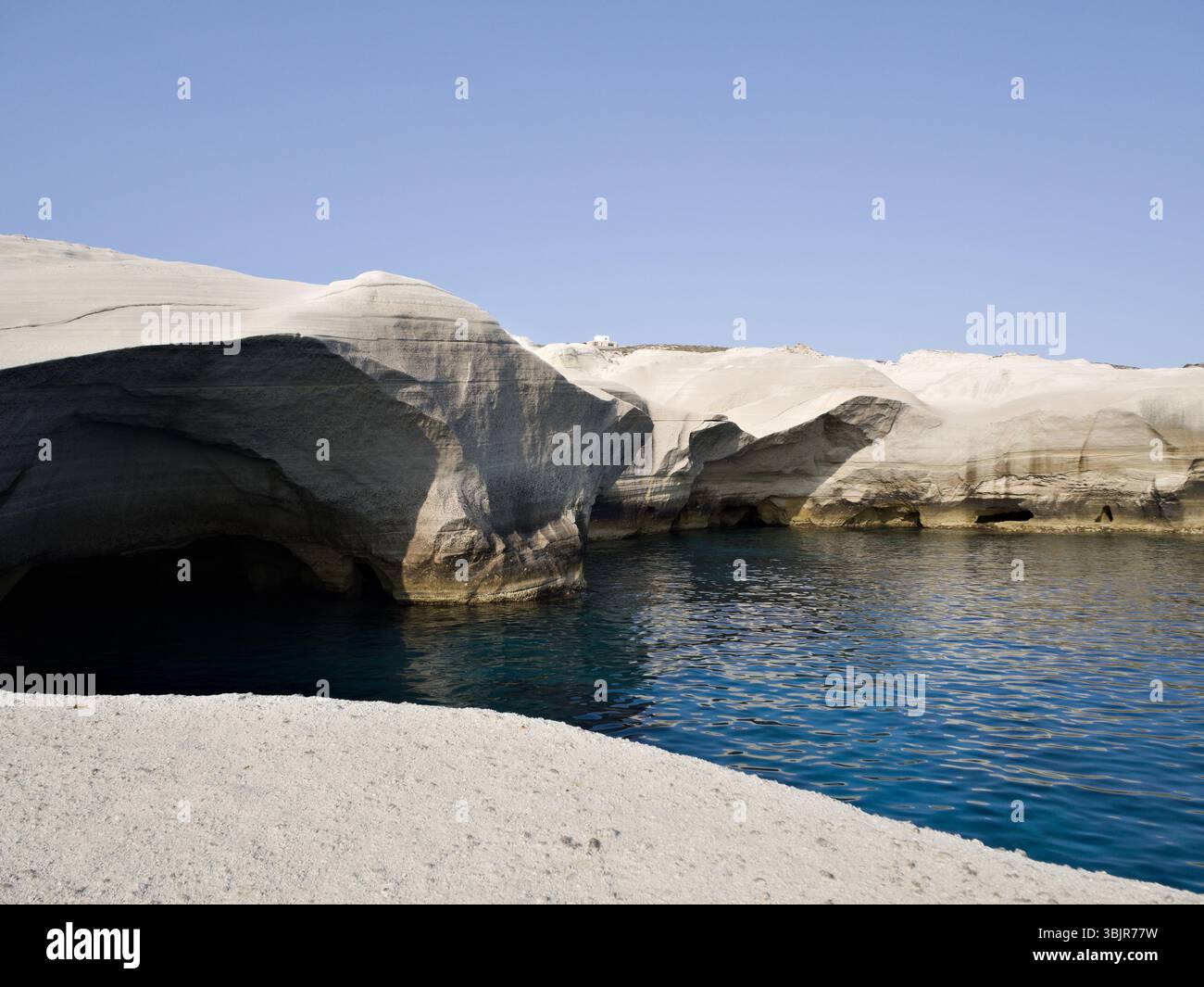 Grotte marine naturali costiere scavate nelle bianche scogliere vulcaniche di Sarakiniko, isola di Milos, Cicladi Foto Stock
