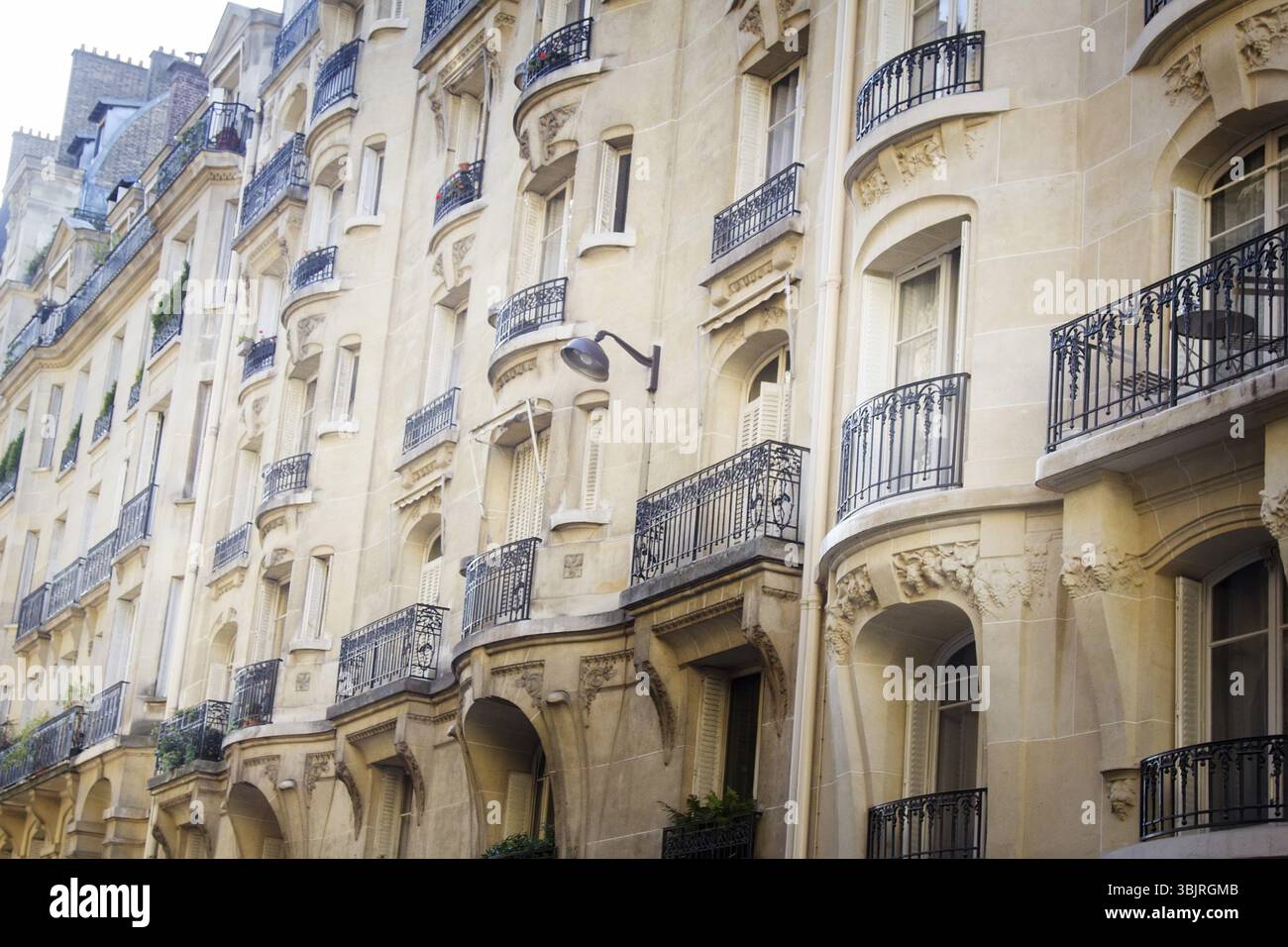 Parigi, Francia vecchio edificio con dritto e balconi rotondi, tende, stucco. Strada parigina Foto Stock