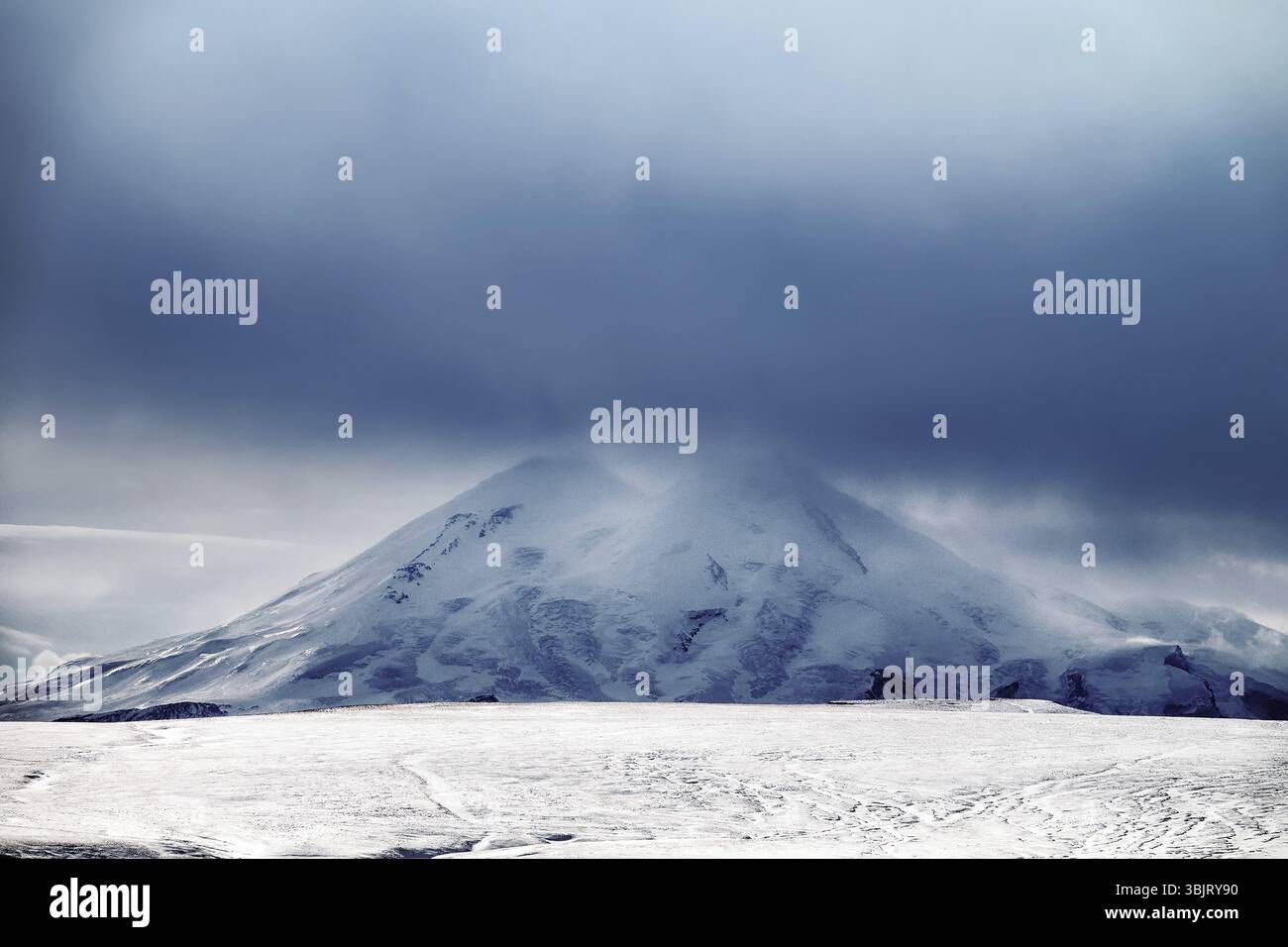Dietro queste colline invernali si può vedere la catena montuosa del grande Caucaso (montagne adolescenti) - confine geografico dell'Asia e dell'Europa, parte del mondo Foto Stock