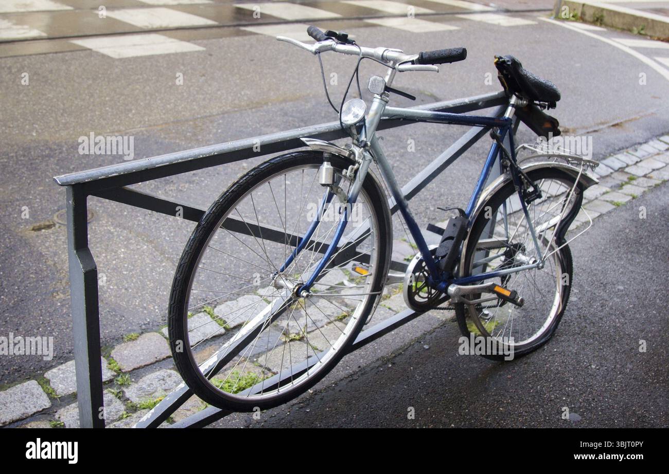 Rotto dopo un incidente in bici da corsa a recinzione. Bicicletta con una ruota rotta sulla strada Foto Stock