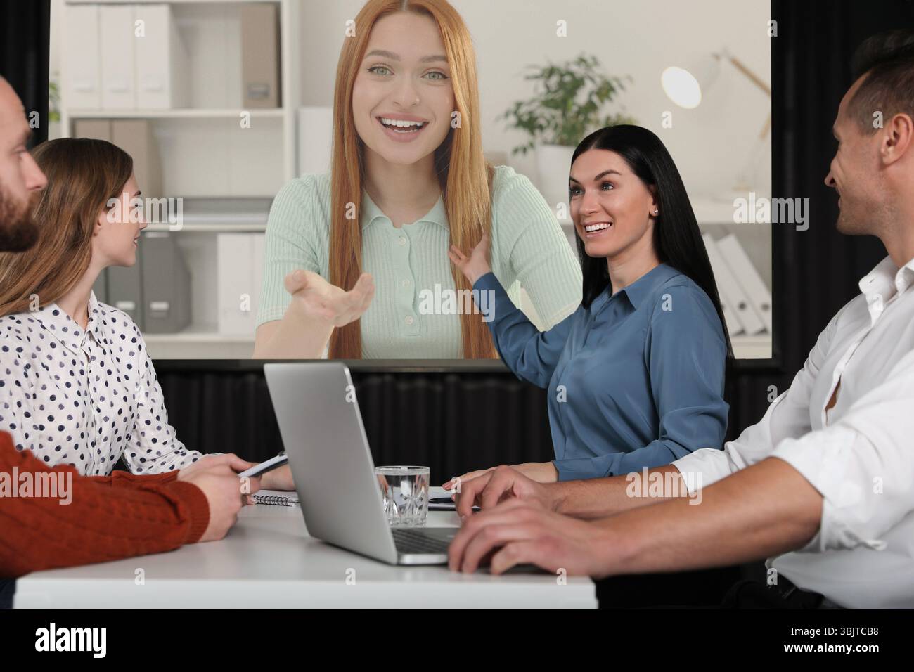 Gruppo di persone che partecipano a una conferenza aziendale al chiuso. Altoparlante sullo schermo di proiezione Foto Stock