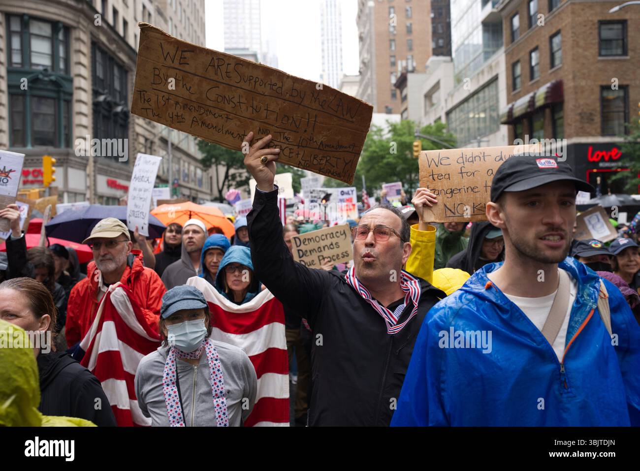 Una manifestazione a New York vede i manifestanti che tengono segnali a favore dei diritti costituzionali e dei processi democratici. La scena e' all'aria aperta Foto Stock