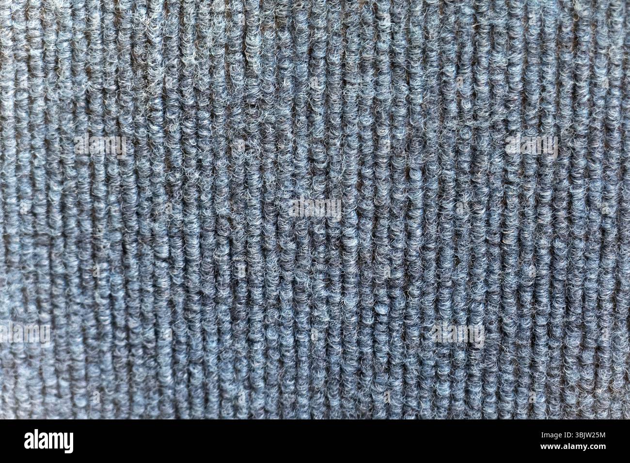 Una vista dettagliata cattura l'intricata trama del tessuto con linee verticali blu. Il tessuto sembra resistente ed è probabilmente utilizzato per l'abbigliamento Foto Stock