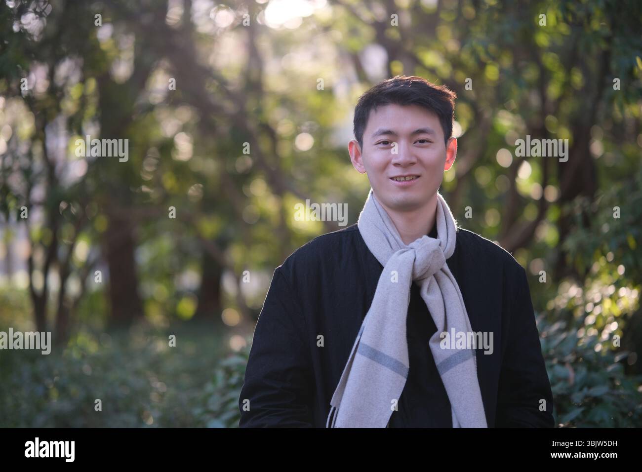 Ritratto di un giovane asiatico sorridere all'aperto in inverno Foto Stock