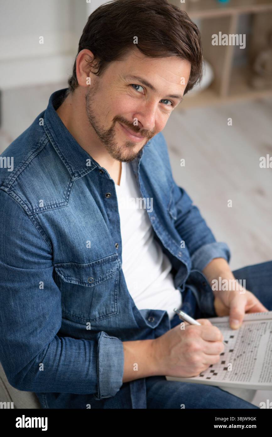la mano dell'uomo felice sta riempiendo le parole con parole incrociate Foto Stock