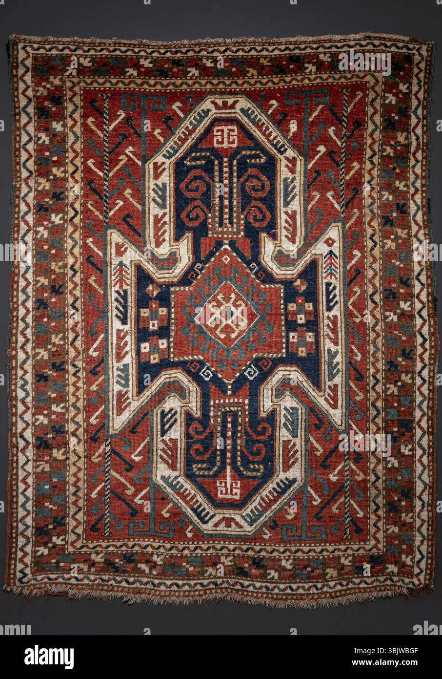 Tappeto orientale tradizionale splendidamente dettagliato caratterizzato da vivaci disegni tribali geometrici e simmetrici. Perfetto per aggiungere un tocco di elega culturale Foto Stock