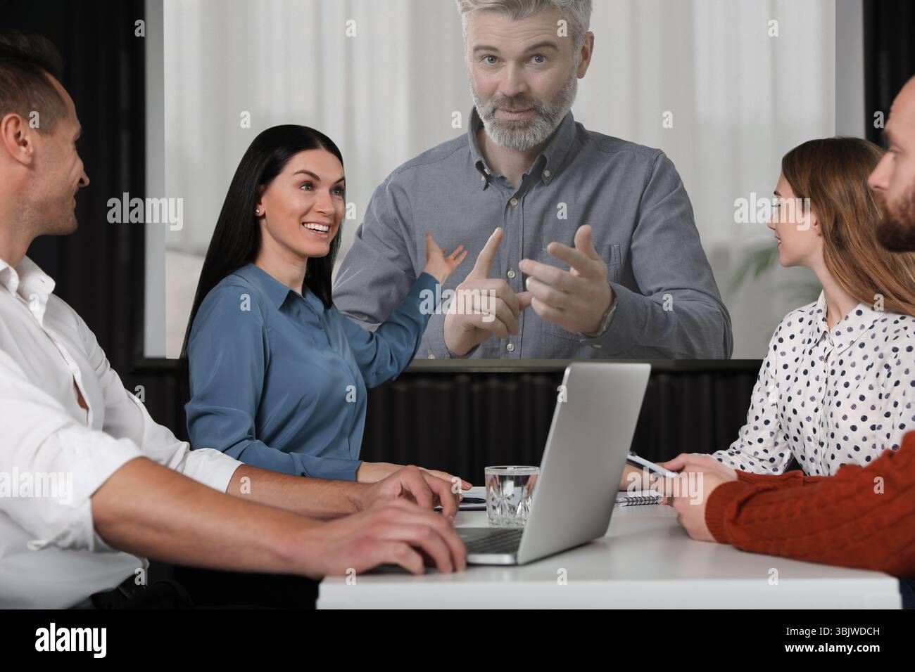 Gruppo di persone che partecipano a una conferenza aziendale al chiuso. Altoparlante sullo schermo di proiezione Foto Stock