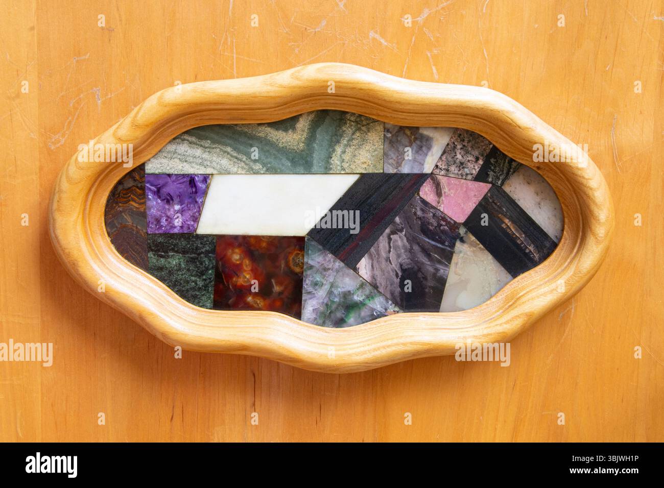 Raccolta di pietre naturali quali larimar, ematite, dolomite, skarn, jasper, fluorite e corniolo in mosaico lucido con cornice in legno come pittur Foto Stock