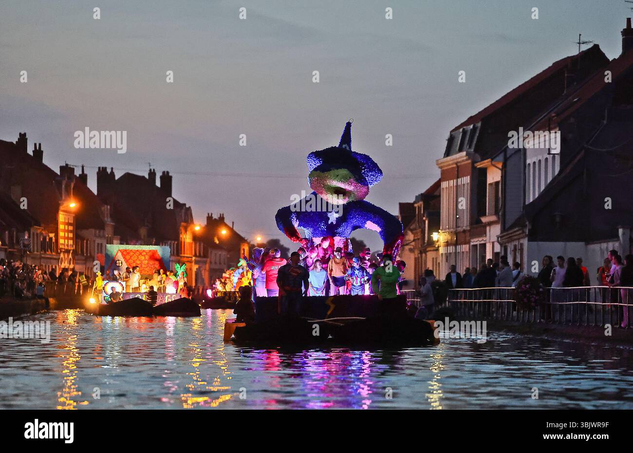 Saint-Omer (Francia settentrionale): La processione nautica annuale delle tradizionali barche a fondo piatto. Parata d'acqua di galleggianti floreali sul fiume AA e lungo Foto Stock