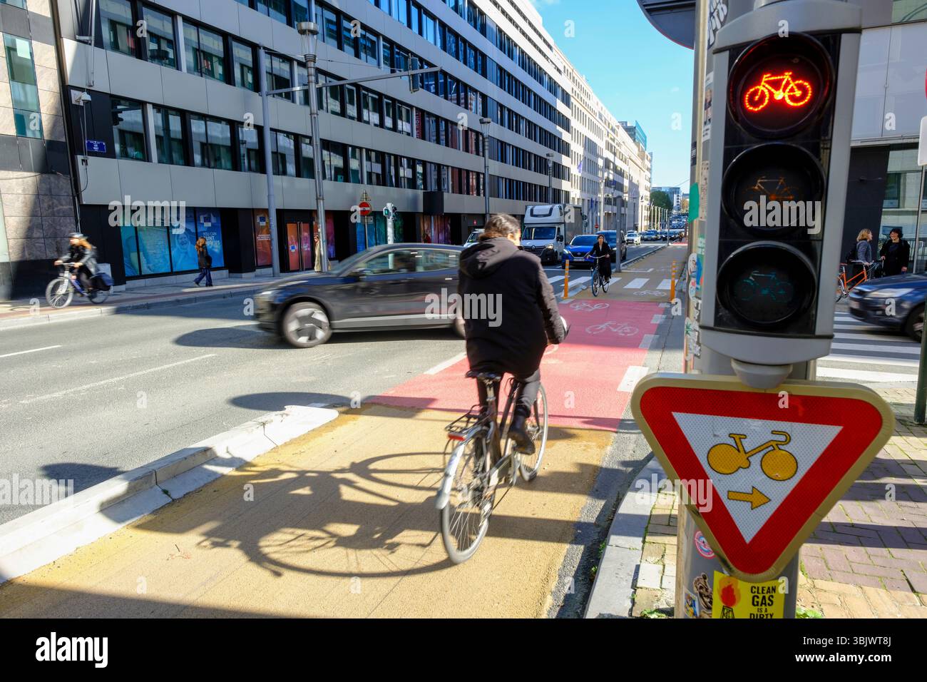 Belgio, Bruxelles: Infrastrutture ciclabili in città per un trasporto sostenibile, piste ciclabili. Ciclisti su una pista ciclabile all'angolo della strada "rue Foto Stock