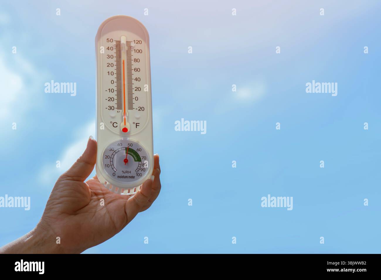 Termometro a mano umana con sfondo cielo. Concetto di riscaldamento globale. Primo piano, immagine verticale, spazio di copia per il testo. Foto Stock