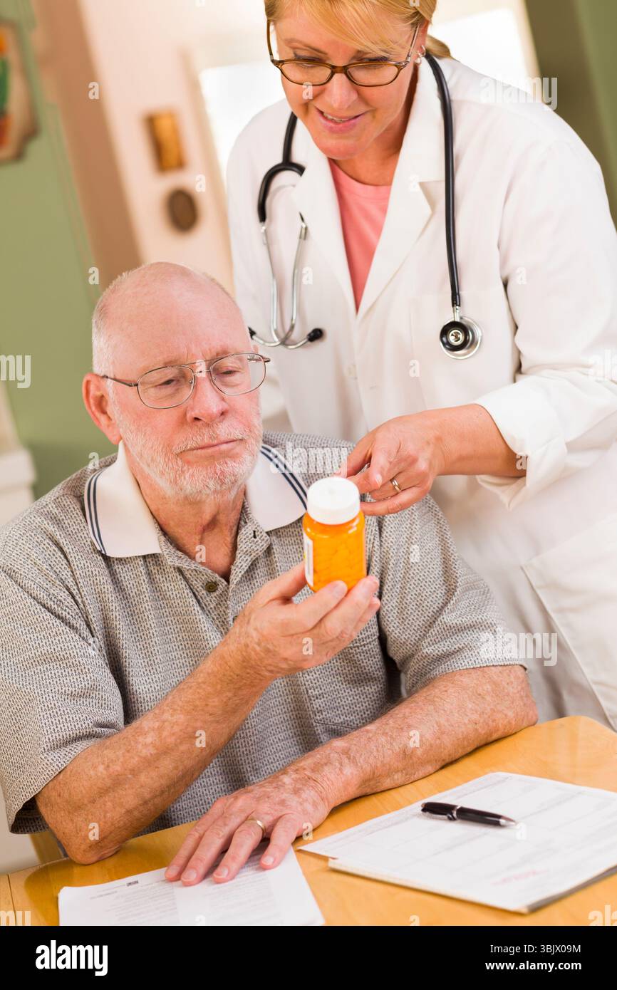 Medico o infermiere che spiega la medicina prescritta all'uomo anziano Foto Stock