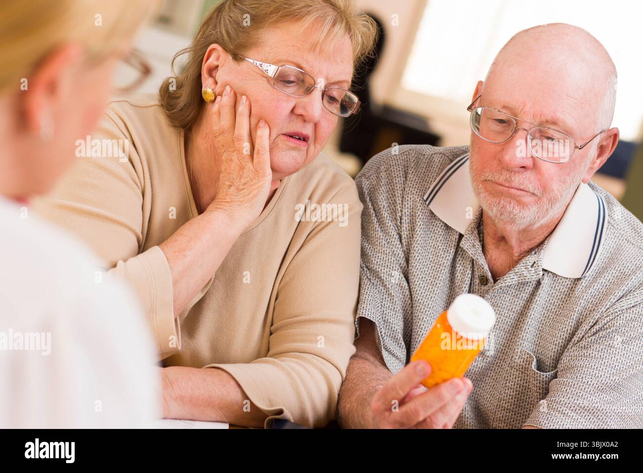 Medico o infermiere che spiega la medicina prescritta alla coppia senior Foto Stock
