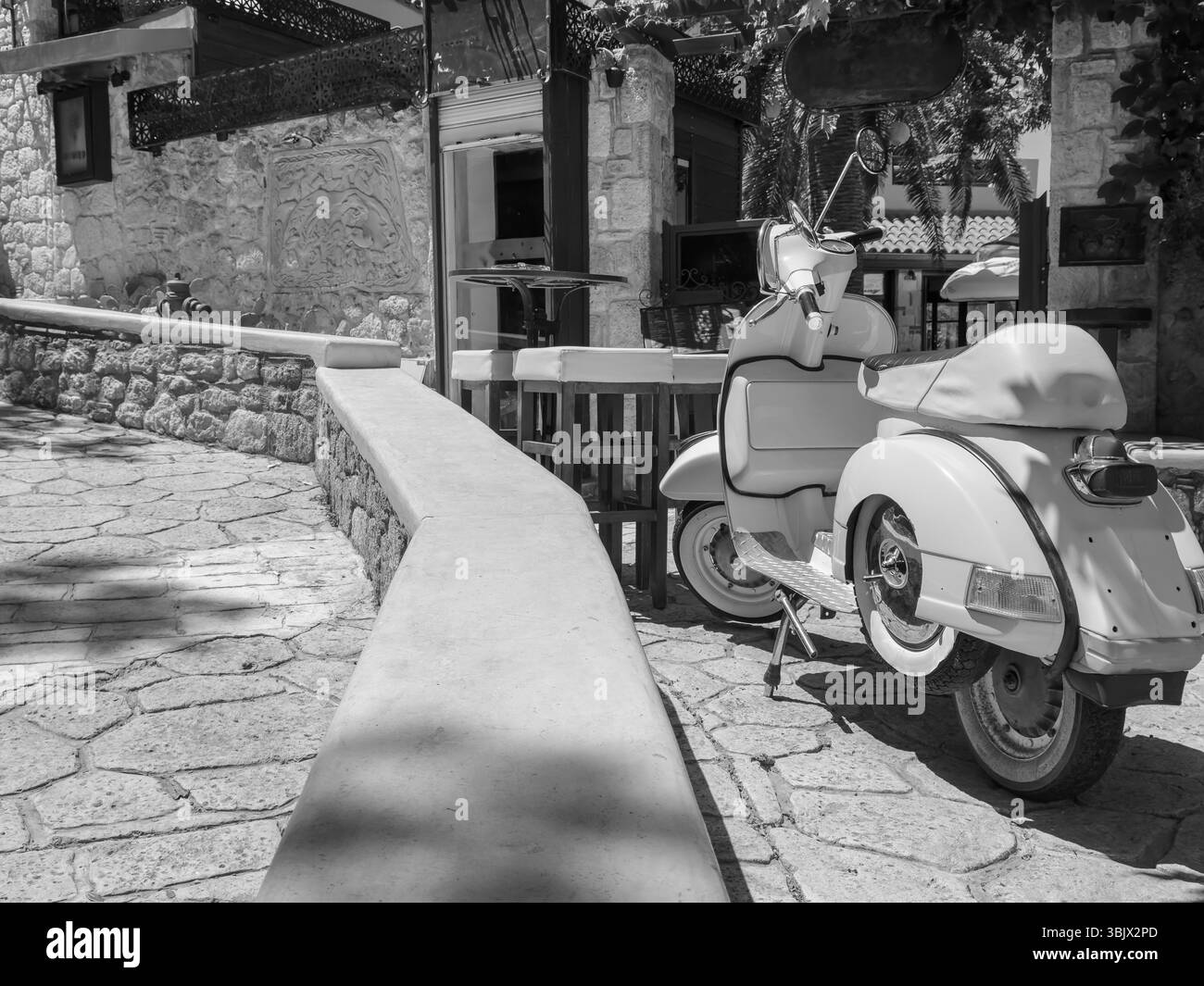 Foto in bianco e nero di una città vecchia con scooter retrò rossi in italia Foto Stock