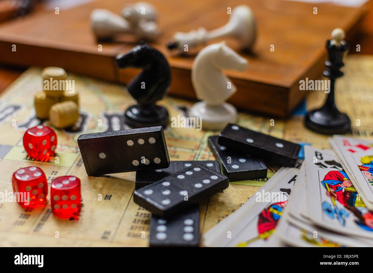 Un primo piano di vari giochi da tavolo classici. La scena presenta una collezione di oggetti per il tempo libero e per hobby, tra cui tessere, dadi rossi e giochi Foto Stock