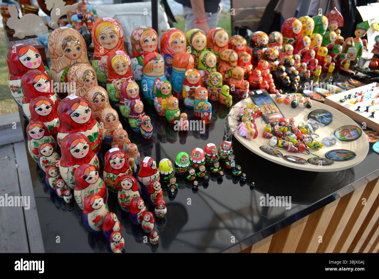 Arte, artigianato e tradizione russa. Bellissime e famose bambole di legno scolpite in tronchi in mostra nel mercato locale. bellezza dei volti, espressioni visive, colori Foto Stock