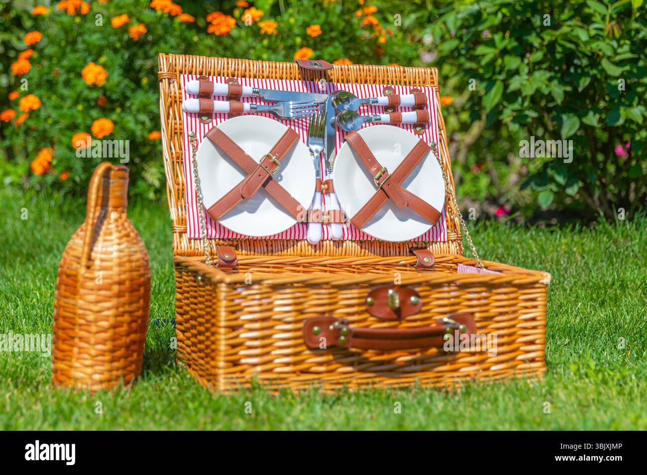 Cesto picnic sul verde prato soleggiato nel parco Foto Stock