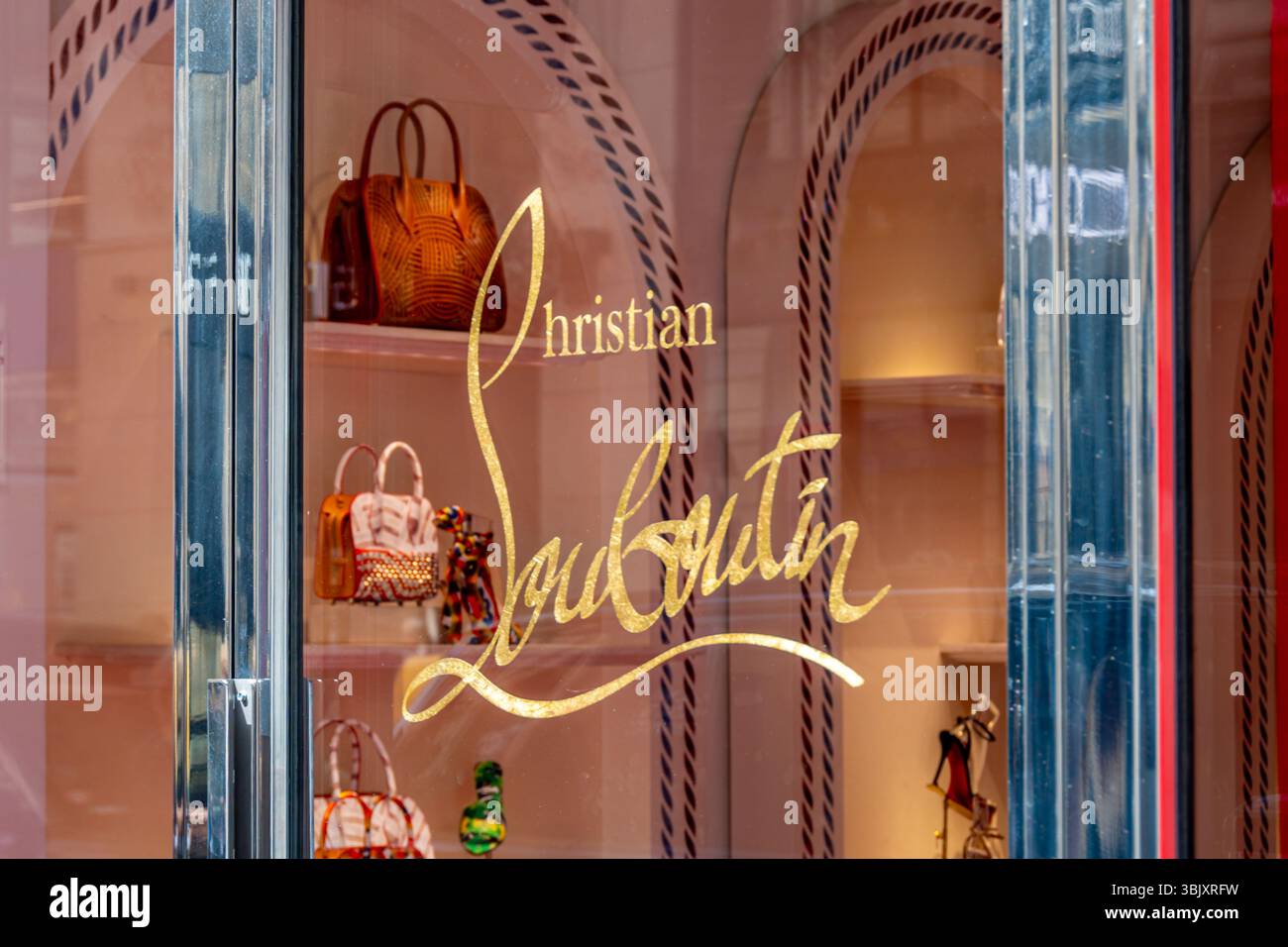 Insegna e logo sulla porta di una boutique di Louboutin a Parigi, Francia. Christian Louboutin è un designer francese di borse e scarpe di lusso Foto Stock