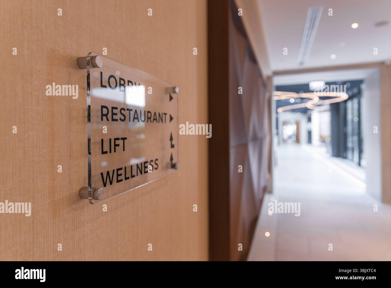 Moderno corridoio dell'hotel con segni direzionali e design geometrico Foto Stock