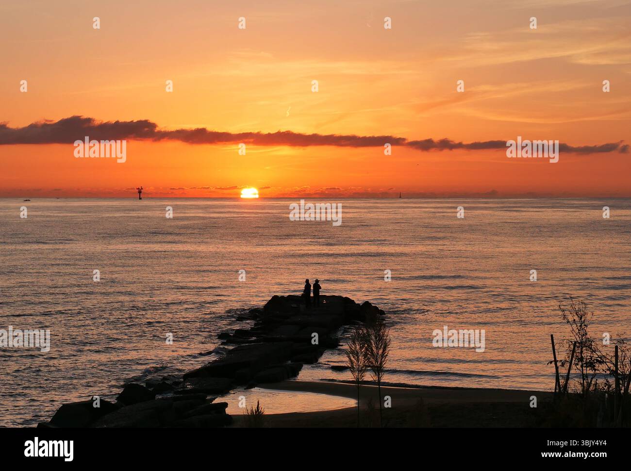 La luce dell'alba Crotone un nuovo giorno e due persone in contemplazione Foto Stock