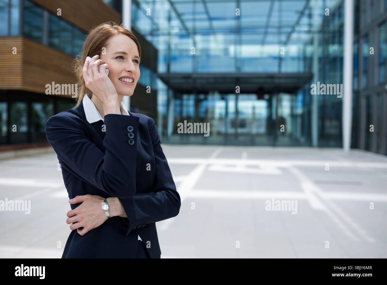 Edificio per uffici con pareti a tende di vetro e pannelli di legno accanto alla piazza piastrellata, spazio per fotocopie Foto Stock