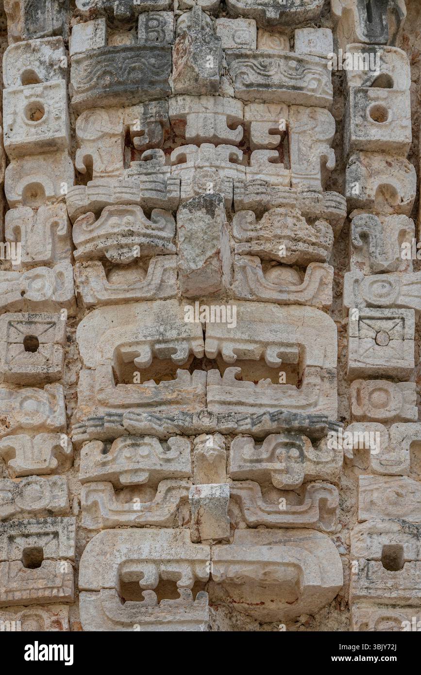 Dettagliata parete in pietra Maya con ripetitivi motivi mascherine e volti di dio della pioggia Chaac in Messico, penisola dello Yucatan, unnery di Uxmal. Foto Stock