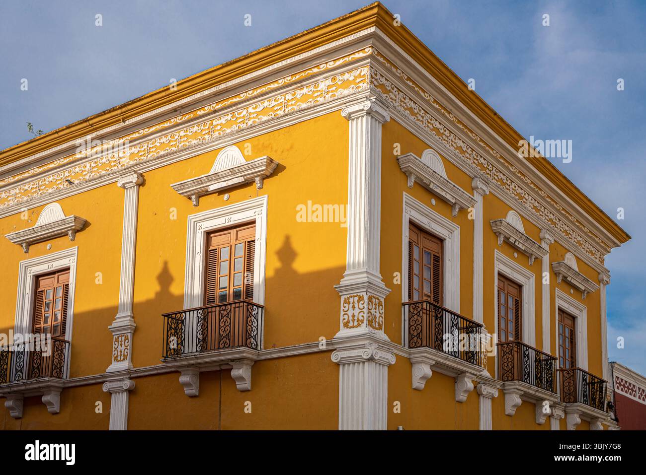 Casa coloniale gialla con colonne neoclassiche bianche e balconi decorati in Messico, penisola dello Yucatan, quartiere storico di Campeche. Foto Stock