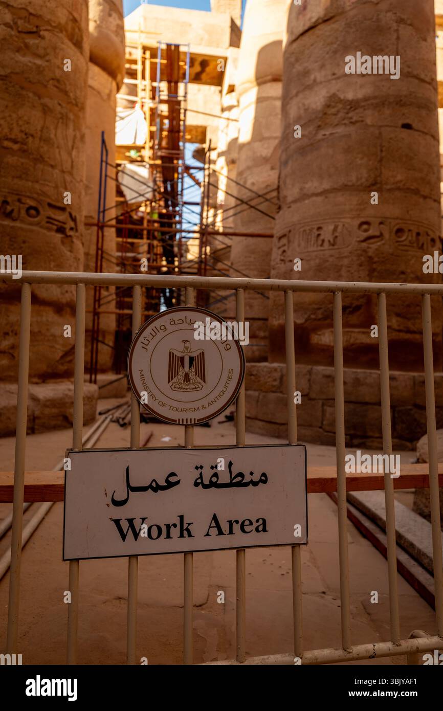 Il Ministero del Turismo e delle Antichità ha designato un'area di lavoro all'interno del complesso del Tempio di Karnak, che potrebbe essere oggetto di interventi di restauro o conservazione, come indicato dall'impalcatura visibile dietro la barriera. Foto Stock