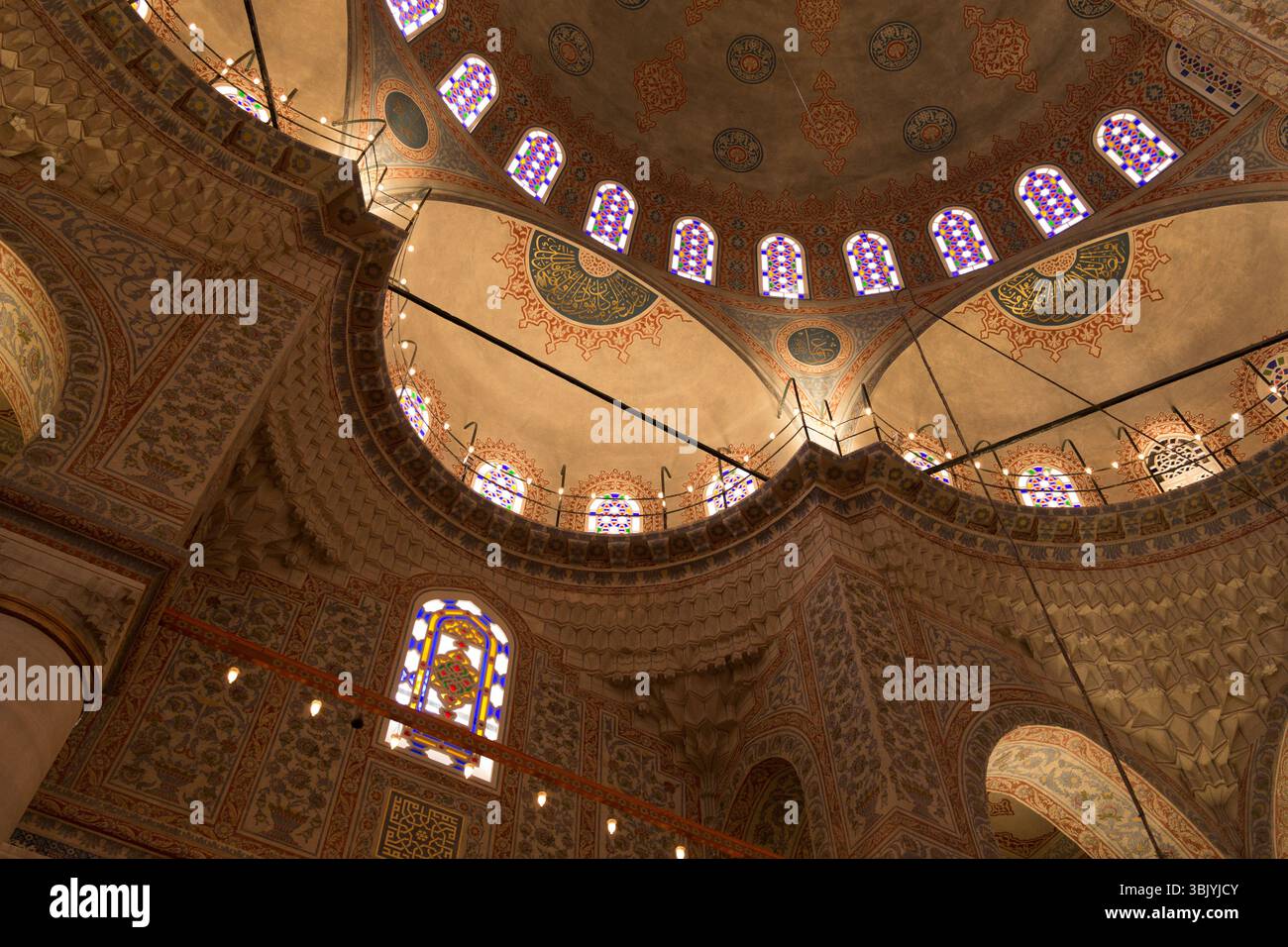 I visitatori potranno ammirare l'elaborato design del soffitto e le colorate vetrate di una moschea storica, catturando lo spirito della ricca cultura di Istanbul. Foto Stock