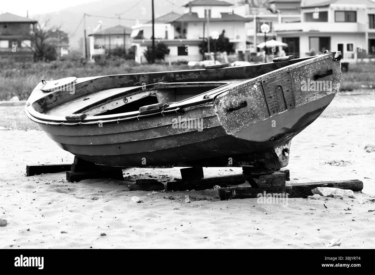 Barca da pesca abbandonata sulla riva in bianco e nero Foto Stock