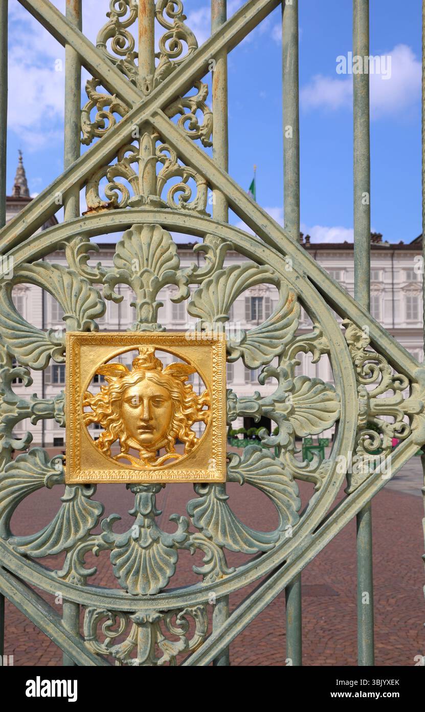 Torino, TO, Italia - 3 giugno 2025: Dettaglio della porta del Palazzo reale con la faccia dorata del sole e il cielo azzurro Foto Stock