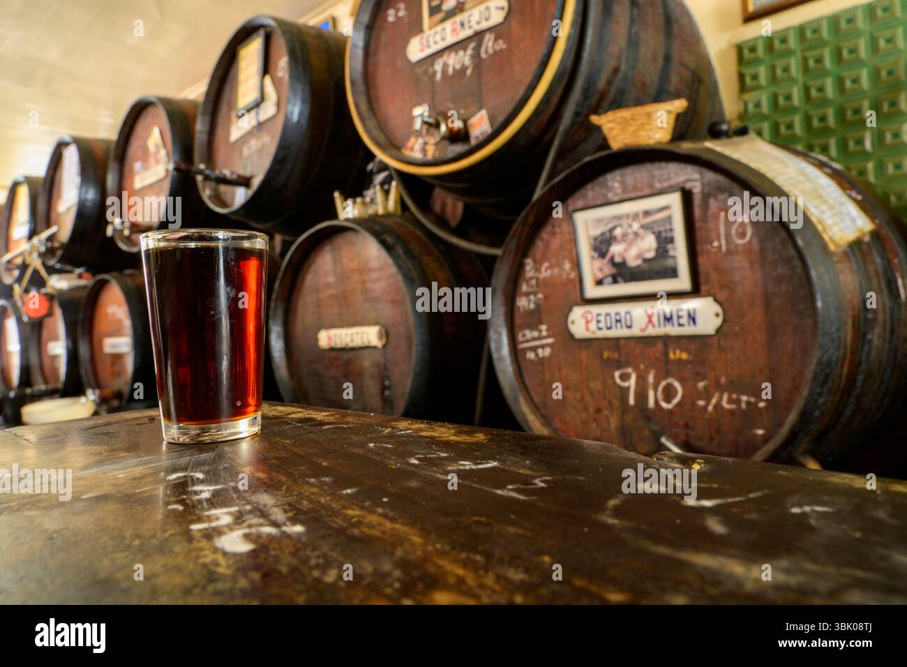 Un bicchiere di vino dolce al bar de la Taberna Antigua Casa de Guardia, Malaga, Andalusia, Spagna. Foto Stock