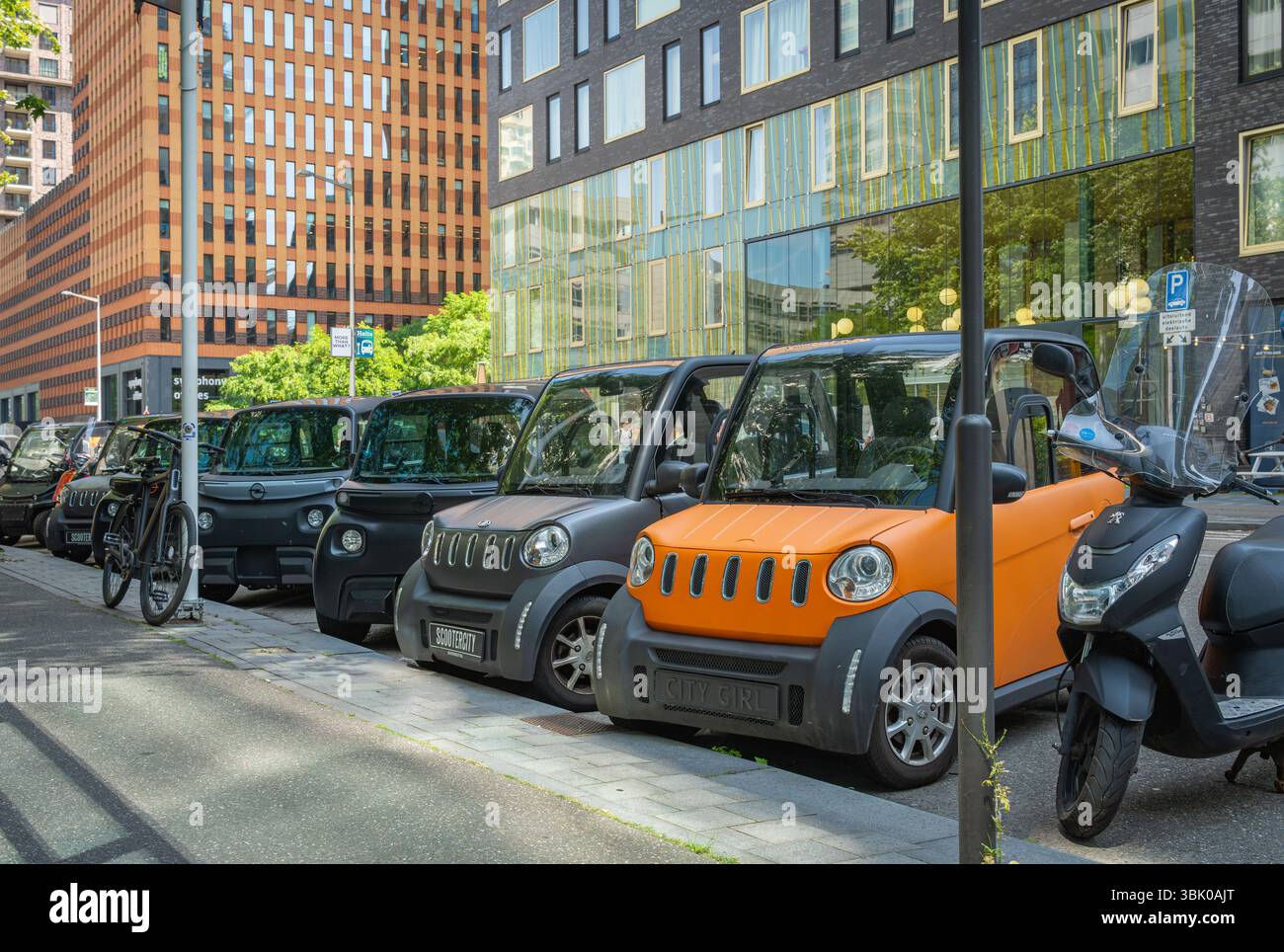Amsterdam, Paesi Bassi, 16.06.2025, spostare Citycar piccoli veicoli elettrici parcheggiati sul ciglio della strada nel quartiere finanziario Zuidas di Amsterdam Foto Stock
