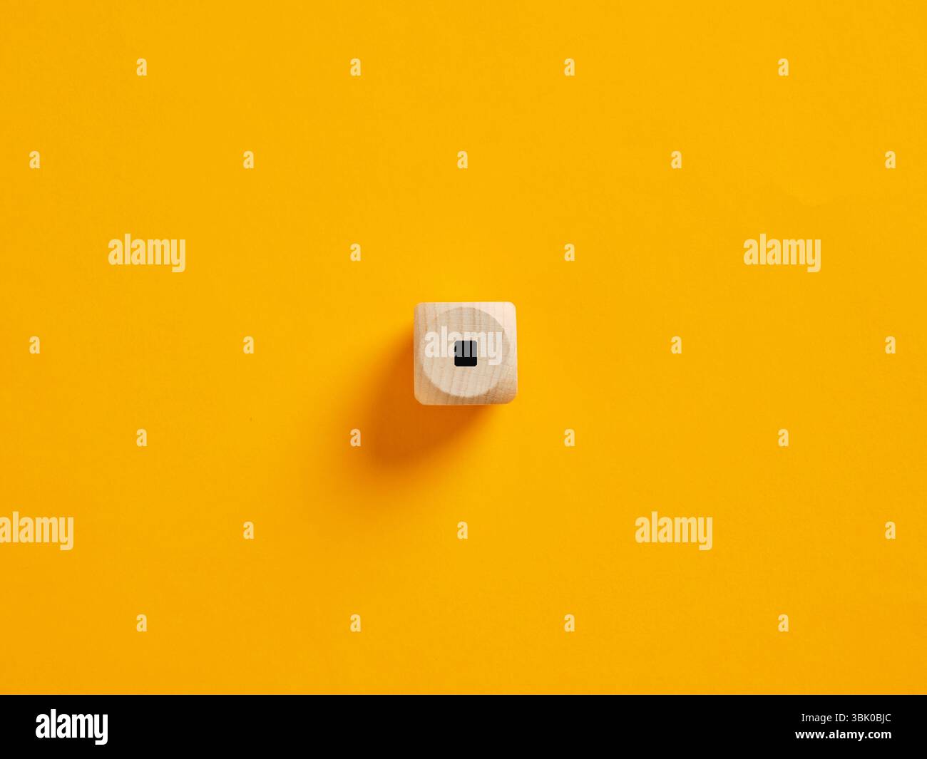 Punto di punteggiatura completo o punto su un cubo di legno su sfondo giallo brillante. Per mettere fine o fermare i concetti. Foto Stock