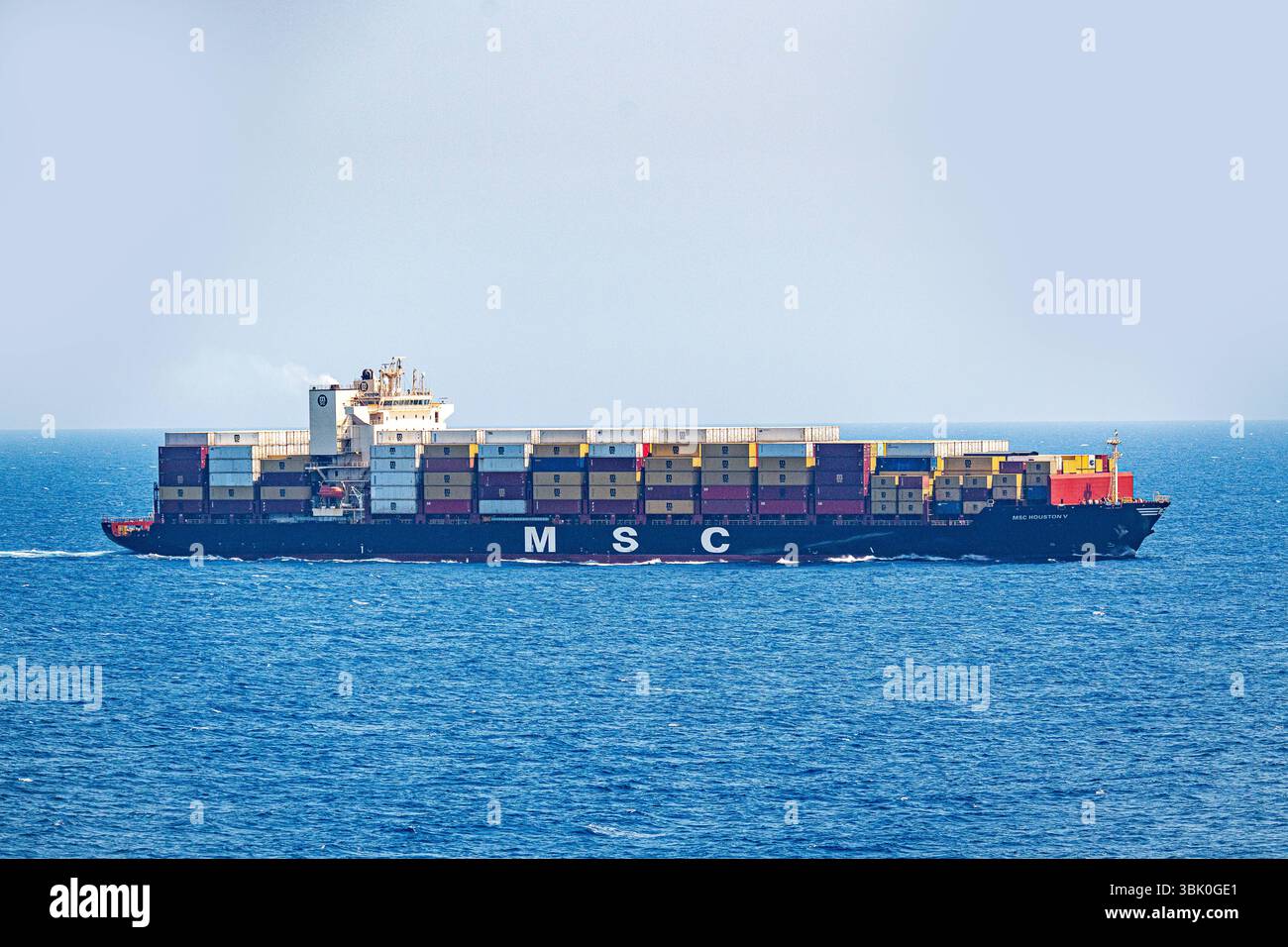 Mediterraneo, Europa - 11 giugno 2025: Una grande nave portacontainer della compagnia di navigazione MSC MSC Houston V trasporta numerosi container attraverso il mare aperto - un simbolo del commercio globale, dei trasporti e della logistica moderna in alto mare in tutta Europa verso il mondo. *** Ein Großes Containerschiff der Reederei MSC Houston V transportiert zahlreiche container über das offene Meer Symbol für globalen Handel, Transport und moderne Logistik auf hoher SEE über Europa in Die Welt. Foto Stock