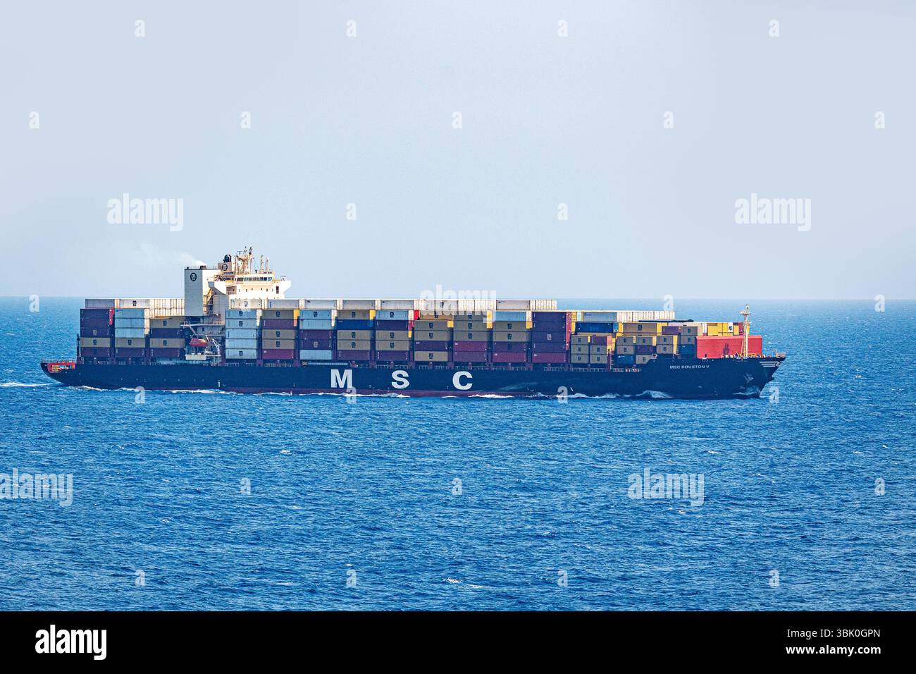 Mediterraneo, Europa - 11 giugno 2025: Una grande nave portacontainer della compagnia di navigazione MSC MSC Houston V trasporta numerosi container attraverso il mare aperto - un simbolo del commercio globale, dei trasporti e della logistica moderna in alto mare in tutta Europa verso il mondo. *** Ein Großes Containerschiff der Reederei MSC Houston V transportiert zahlreiche container über das offene Meer Symbol für globalen Handel, Transport und moderne Logistik auf hoher SEE über Europa in Die Welt. Foto Stock
