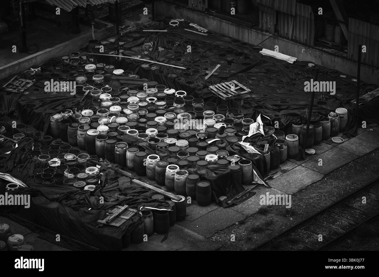 Foto di una discarica di rifiuti chimici con un sacco di barili Foto Stock