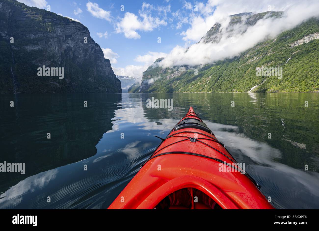 Gita in kayak sul Geirangerfjord, punta di un kayak rosso nel fiordo con riflessi, suggestivo paesaggio del fiordo, vista in prima persona a Geiranger e molto altro ancora Foto Stock
