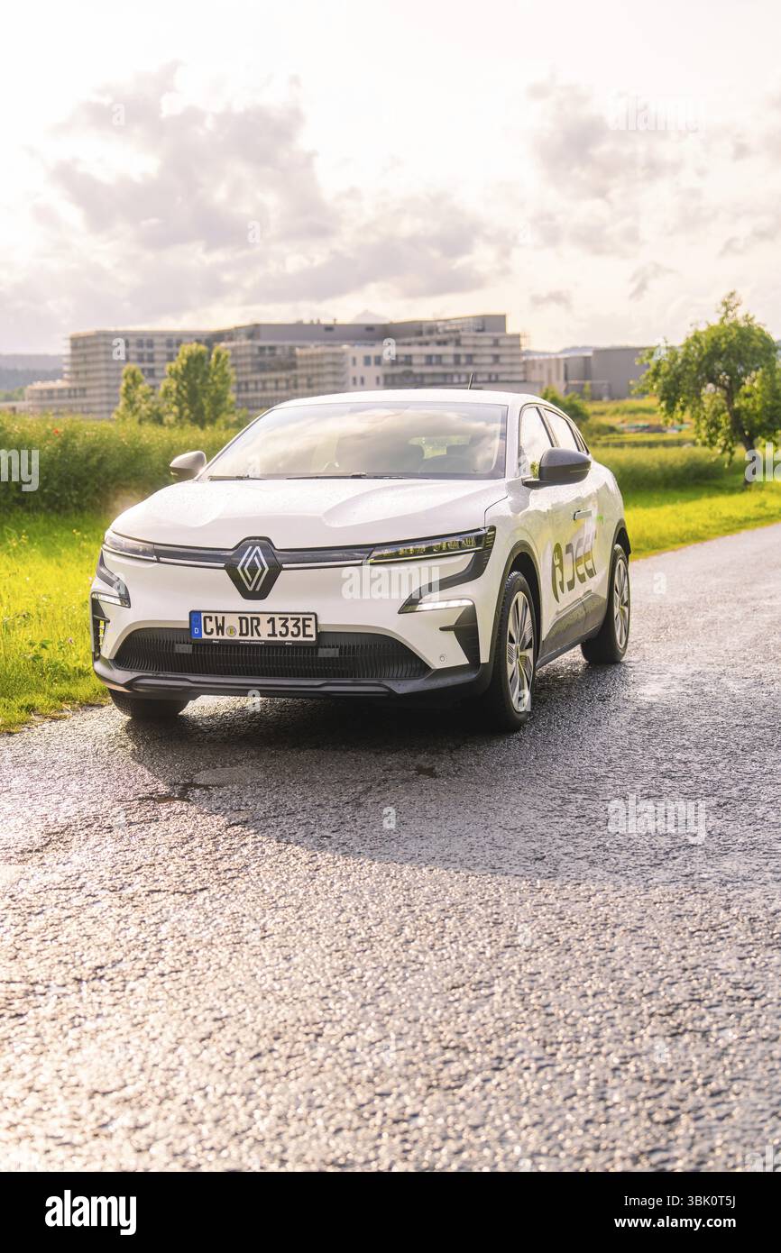 Auto Renault bianca su una strada con campi e paesaggio urbano sullo sfondo, Renault Megane, Deer e Carsharing, auto elettrica, Calw, foresta Nera, GE Foto Stock