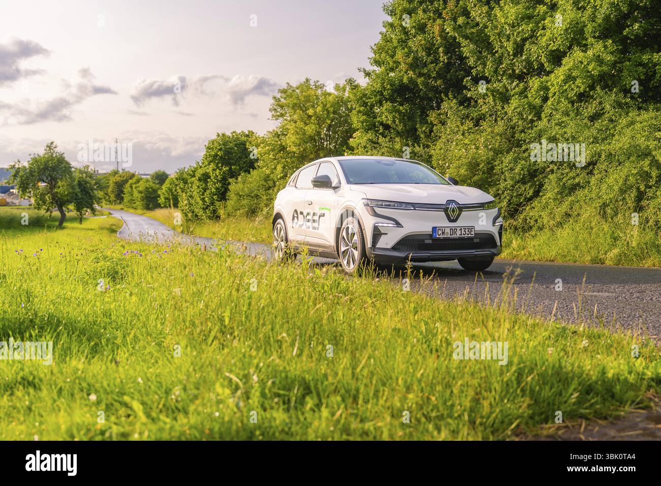Auto Renault su strada, circondata da verdi alberi e prati, Renault Megane, Deer e Carsharing, auto elettrica, Calw, foresta Nera, Germania, Europa Foto Stock