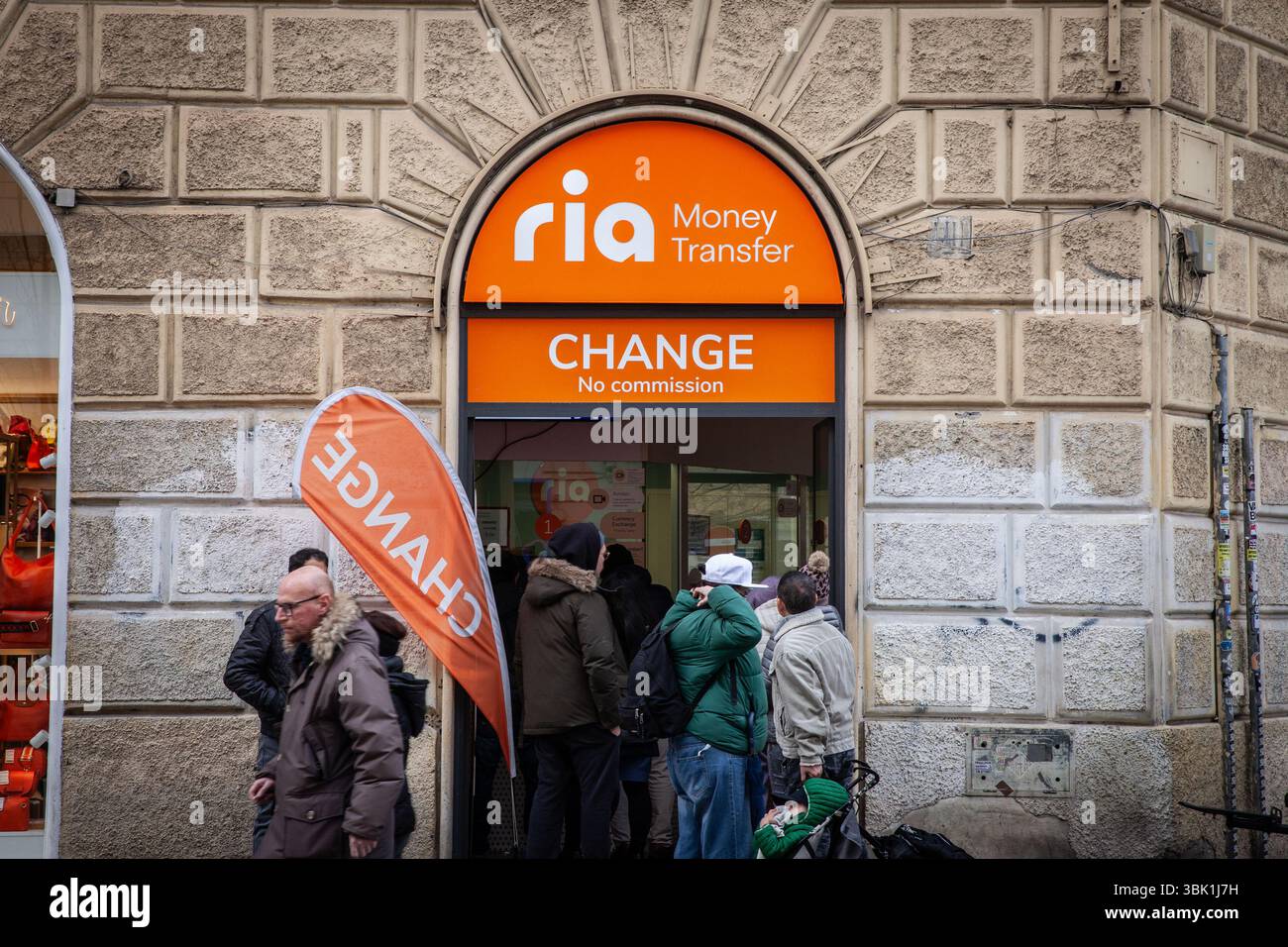 ROMA, ITALIA - 15 GENNAIO 2025: Persone in coda presso un ufficio Ria Money Transfer nel centro di Roma, Ria è una società di servizi finanziari americana specializzata in servizi finanziari Foto Stock