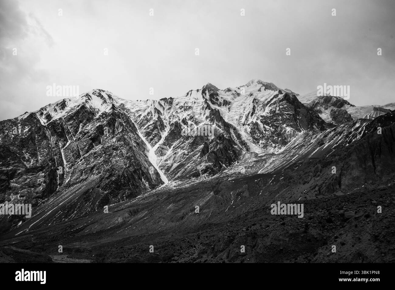 Maestose montagne Kunlun innevate sotto un cielo cupo, lo Xinjiang meridionale. Picchi spettacolari avvolti dalla nebbia。 Foto Stock